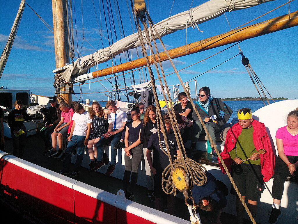 Eine Gruppe von Jugendlichen auf einem Segelschiff.